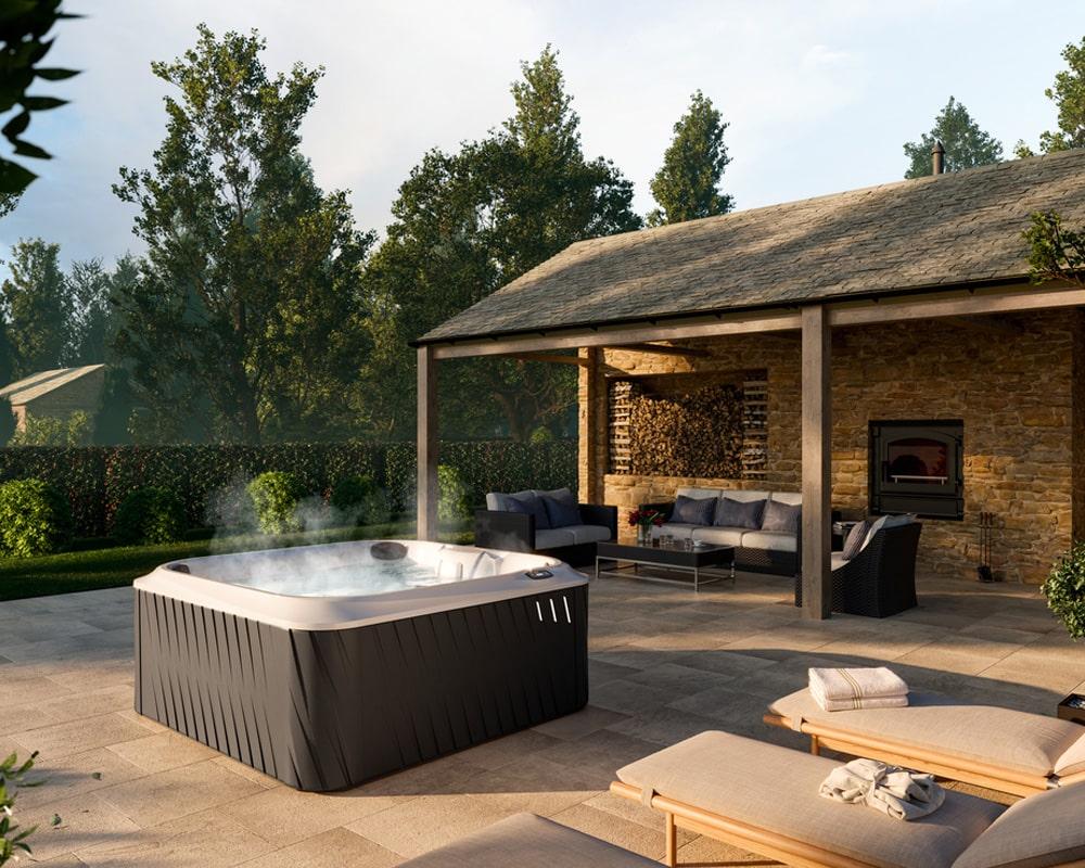 steaming Jacuzzi J-245 hot tub, comfortable seating area under a covered patio, surrounded by lush greenery