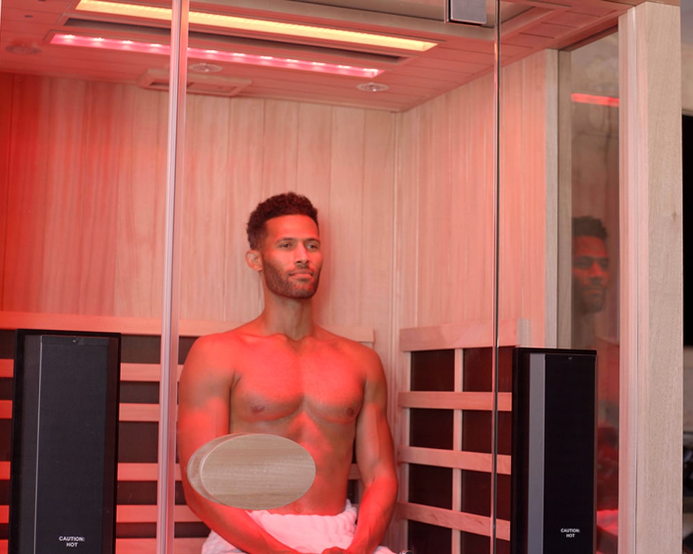 man is siting in an infrared sauna